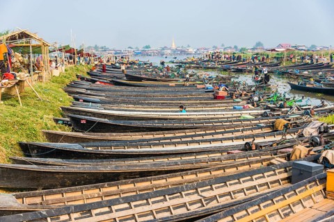 Many wooden boats lined up at dock in the harbor