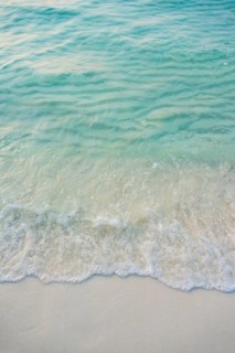 Waves on sandy beach with turquoise water at Koh Tui Beach