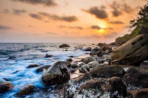 Sunset at rocky coast near Long Beach in Sok San village on Koh Rong island