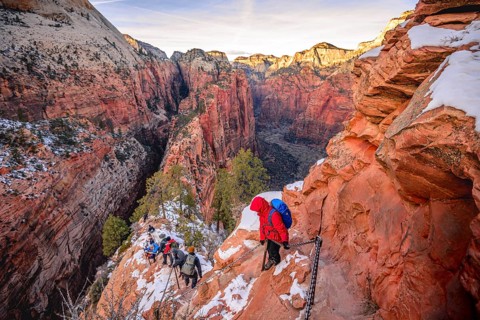 Young woman hikes on the via ferrata descending from Angels Landing