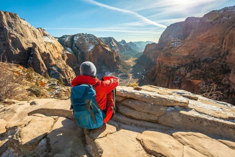 Young woman looking into the distance from Angels Landing to Zion Canyon