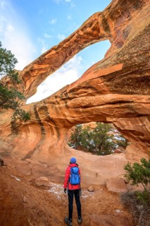 Hiker in front of Double O Arch