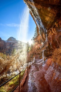 Waterfall falls from overhanging rock in winter