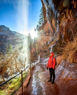 Female hiker in front of waterfall
