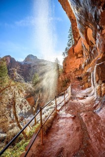 Waterfall falls from overhanging rock in winter
