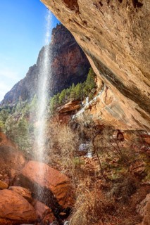 Waterfall falling from overhanging rock in winter