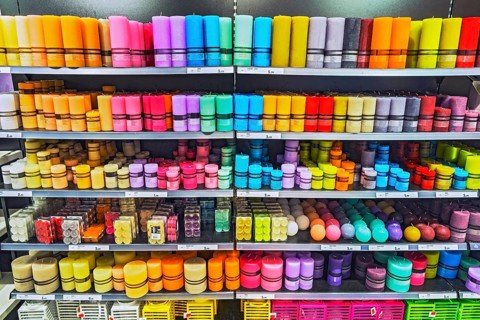 Shelves with different coloured candles in the supermarket