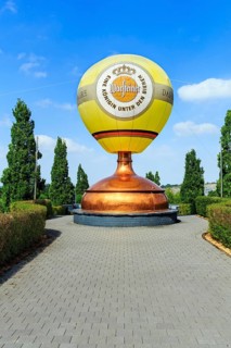 Hot air balloon on sculpture of a brewing kettle