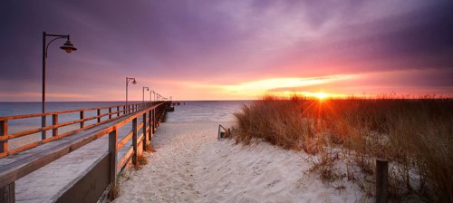 Pier on the beach at sunrise