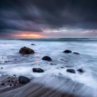 Stormy sea with dark clouds at sunset on the beach of the Baltic Sea
