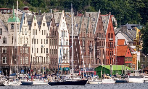Sailing ships in front of row of houses