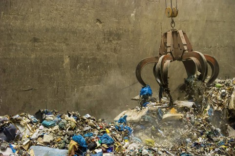 A crane transports waste in a waste-to-energy plant