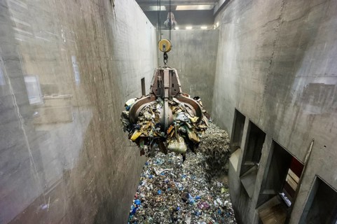 Gripper arm over pile of trash