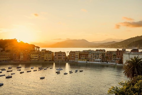 View of the village with harbour in the bay Baia del Silenzio at sunset