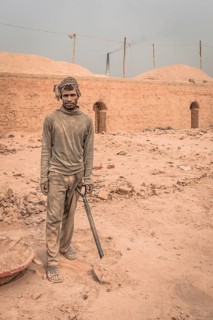 Worker with shovel in a brickyard