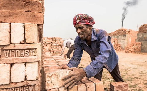 Brick factory worker stacks bricks