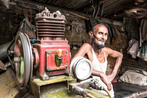 Portrait of a worker in front of an engine