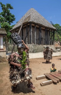 Dancers in traditional clothing wearing carved masks
