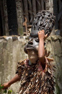 Dancer in traditional clothing wearing carved mask