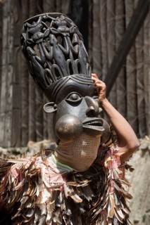 Dancer in traditional clothing wearing carved mask