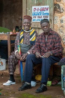 Two men sitting on bench at market