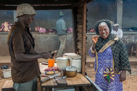 Woman eating grilled meat at street stand