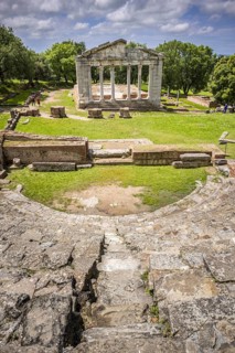 Odeon with rows of seats in front of the ruins of a Doric Buleuterion