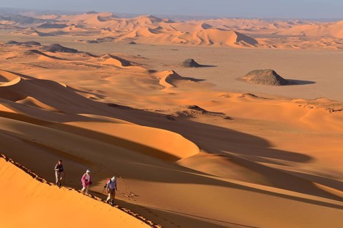 Group of people hiking in the sanddunes of Egedi In Djerane