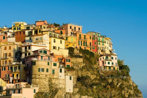 Colorful houses of Manarola town crammed on a hill on the coast of the Mediterranean Sea