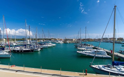 Sailing and motor boats are anchored in the harbour