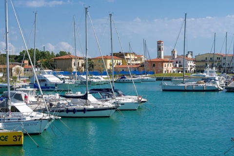 Sailing and motor boats are anchored in the harbour