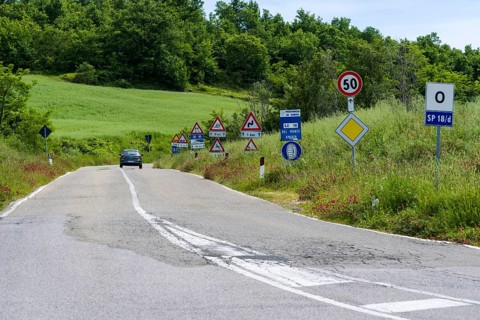 Road flanked bei many traffic signs