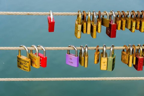Many colorful locks are locked at a steel cable for a love vow