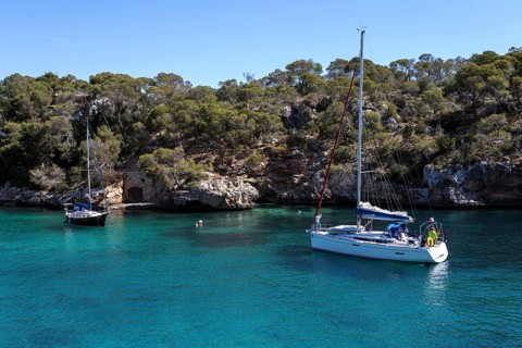 Sailboats anchor in the bay of Cala Figuera