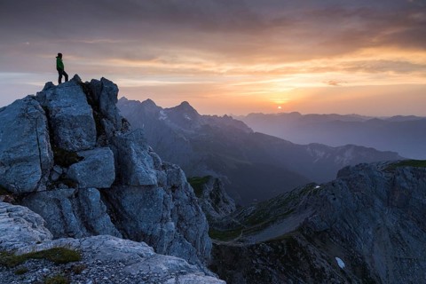 Hiker on top of the Dreitorspitze at sunset