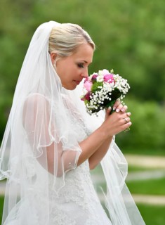 Bride in wedding dress with bridal bouquet and veil