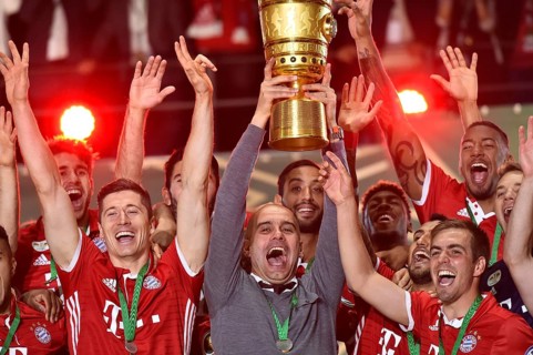 Coach Josep Pep Guardiola lifting the DFB Cup in the air