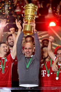 Coach Josep Pep Guardiola lifting the DFB Cup in the air