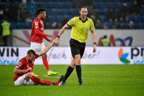 Referee Sascha Stegemann helps Daniel Brosinski 1st FSV Mainz 05 on his feet