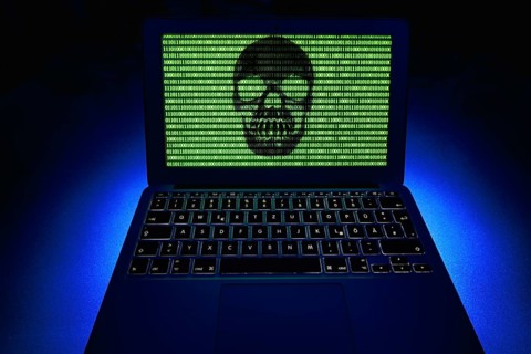 Laptop with skull and crossbones and binary numbers on screen