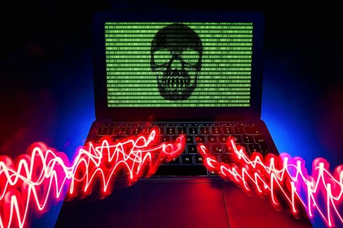 Laptop with skull and crossbones and binary numbers on screen