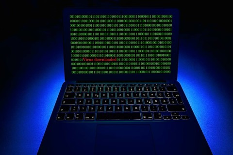 Laptop with binary numbers on screen. Symbol image malware