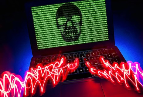 Laptop with skull and crossbones and binary numbers on screen