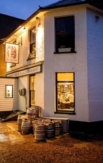 Lights at a pub with barrels outside the entrance