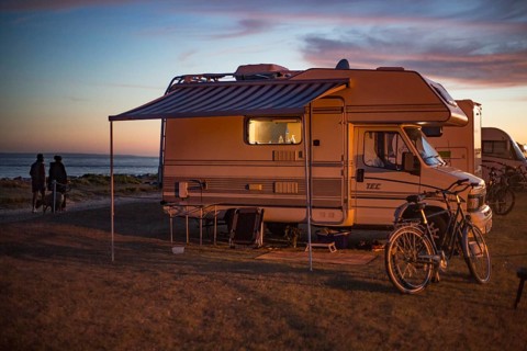 Motorhome in the evening on a pitch by the sea at sunset