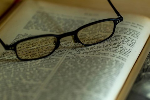 Opened old book with glasses