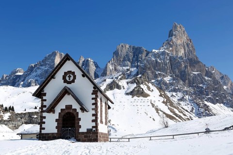 Chapel at the mountain pass Passo Rolle with snow