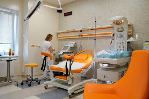 Nurse in an empty modern delivery room with birthing chair
