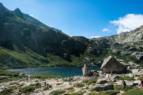 Hikers at mountain lake Lac de Melo