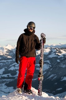 Skier stands at the piste and holds ski